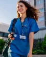 Médica sorridente usando uniforme azul com estetoscópio.