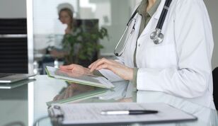 Médico usando tablet em consultório moderno